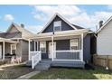 Inviting two-story home with a covered porch, white railings, and a well-maintained lawn under a partly cloudy sky at 1521 Lawton Ave, Indianapolis, IN 46203