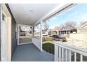 Spacious covered front porch with painted floor and white railings, ideal for outdoor relaxation and neighborhood views at 1521 Lawton Ave, Indianapolis, IN 46203