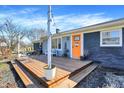 Inviting front porch with seating area and vibrant orange door, perfect for relaxing outdoors at 15415 E 146Th St, Noblesville, IN 46060