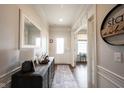 Elegant entryway with hardwood floors, stylish console table, and decorative mirror creating a welcoming ambiance at 16164 Loire Valley Dr, Fishers, IN 46037