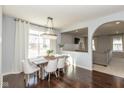 Light-filled dining area featuring hardwood floors, stylish chandelier, and open access to the living room at 18108 Cristin Cir, Westfield, IN 46062