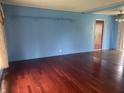 Spacious living room with wood-look flooring, blue walls, and open doorway to another room at 224 Griffin Rd, Indianapolis, IN 46227