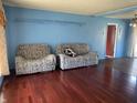Living room with wood floors and blue walls, featuring couches and interior doors at 224 Griffin Rd, Indianapolis, IN 46227