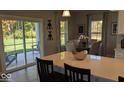 Dining area featuring a wood table, neutral chairs, decorative corkscrew wall art, and large windows with views at 2882 Simsbury Ln, Brownsburg, IN 46112