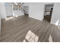Open living area with hardwood floors and staircase, offering a bright and airy feel at 4047 Orchard Valley Ln, Indianapolis, IN 46235