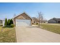 Well-kept home with brick accents, a wide driveway, and green lawn at 4347 Westminster Pl, Columbus, IN 47201