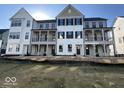 New construction exterior featuring multiple townhomes each with balconies, black shutters and fresh landscaping at 457 Mariposa Trl, Carmel, IN 46032