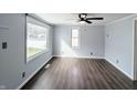 Large bedroom with neutral walls, wood-look flooring, and several windows providing natural light at 611 Della Rd, Columbus, IN 47203