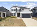 Two-story home featuring gray siding, black shutters, well-manicured lawn, and a two-car garage at 6724 Seattle Slew Dr, Whitestown, IN 46075