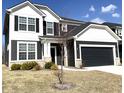 Charming two-story home with black siding, white trim, and attached two-car garage in a residential neighborhood at 6724 Seattle Slew Dr, Whitestown, IN 46075