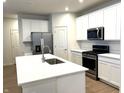 Modern kitchen features white cabinets, quartz countertops, stainless steel appliances, and a large center island at 6724 Seattle Slew Dr, Whitestown, IN 46075