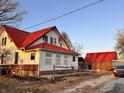 Exterior angle showing the house with its red roof and brick foundation, plus an adjacent outbuilding at 8089 W Old State Road 67, Paragon, IN 46166