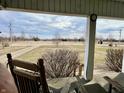 Relaxing covered porch with rocking chairs and a view of the expansive yard and a gravel driveway at 810 S 400 W, Bargersville, IN 46106
