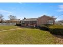 Brick house featuring a covered porch, mature bushes, and a grassy front lawn at 847 Churchman Ave, Beech Grove, IN 46107