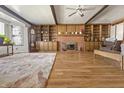 Spacious living room boasts wood floors, a brick fireplace, and built-in shelving at 847 Churchman Ave, Beech Grove, IN 46107