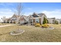 Beautiful suburban home featuring stone accents, green shutters, landscaped yard and mature trees at 8759 Buttonbush Cir, Plainfield, IN 46168