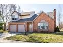 Inviting two-story residence with a brick exterior, attached garage, and manicured lawn at 8873 Falkirk Ct, Indianapolis, IN 46256