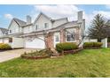 Charming townhome featuring a brick facade, well-kept lawn, and inviting front entrance with tasteful landscaping at 915 Prestwick Dr # D, Indianapolis, IN 46214