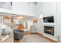 Bright living room featuring a vaulted ceiling, cozy fireplace, and open staircase at 915 Prestwick Dr # D, Indianapolis, IN 46214