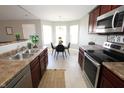 Bright kitchen featuring stainless steel appliances, ample counter space, and an adjacent dining area at 11598 Wilderness Trl, Fishers, IN 46038