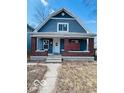 Charming blue two-story home featuring a covered front porch with brick columns at 1534 S State Ave, Indianapolis, IN 46203
