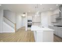 Open kitchen features a large island, stainless steel appliances, and hardwood floors at 15810 Vitalize Run, Fishers, IN 46040
