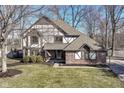 A Tudor-style home with brick and siding, a well-manicured lawn, and a welcoming entrance at 1728 Timber Heights Dr, Carmel, IN 46280