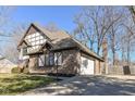 Side view of a brick home with an attached garage and a well-kept lawn at 1728 Timber Heights Dr, Carmel, IN 46280