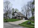 Traditional Tudor-style home featuring a brick facade, attached garage, and green front lawn at 1728 Timber Heights Dr, Carmel, IN 46280
