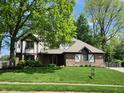 Charming two-story home with brick facade, well-manicured lawn, and mature trees at 1728 Timber Heights Dr, Carmel, IN 46280