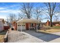 Brick ranch-style home with covered carport and driveway leading to an attached garage at 230 N School St, Fortville, IN 46040