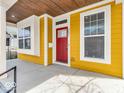 Welcoming front porch with yellow siding, white trim, and a vibrant red front door at 251 Hendricks Pl, Indianapolis, IN 46201
