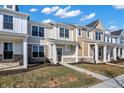 Row of charming townhouses with varied designs, inviting porches, and neat landscaping under a partly cloudy sky at 3923 Wren Dr, Brownsburg, IN 46112