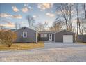 View of the home's side exterior, garage, gravel driveway, and well-maintained yard at 426 Della Rd, Columbus, IN 47203