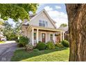 Inviting two-story home with a covered front porch, decorative columns, and lush landscaping at 4707 N Park Ave, Indianapolis, IN 46205