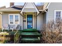 Close-up of a charming front porch featuring a decorative blue door, and a cozy seating area at 4929 Young Ave, Indianapolis, IN 46201