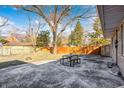 Back patio area with concrete flooring, table, and view of fenced backyard at 5002 Kessler N Blvd, Indianapolis, IN 46228