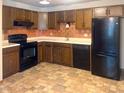 Functional kitchen featuring wood cabinets, black appliances, and tile flooring for a classic design at 5212 Mason Cir, Indianapolis, IN 46254
