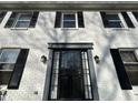 Close-up of the front door showing black security door and white brick with black shutters at 5420 N Arlington Ave, Indianapolis, IN 46226