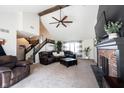 Spacious living room with vaulted ceiling, ceiling fan, fireplace, carpet and staircase at 6149 W Country Ln, Anderson, IN 46011