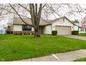 Single-Gathering home with attached two-car garage and a well-maintained green lawn at 6704 Granger Ln, Indianapolis, IN 46268