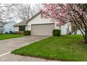Charming single-Gathering home featuring a two-car garage and flowering tree at 6704 Granger Ln, Indianapolis, IN 46268