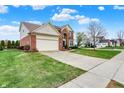 Inviting two-story home with attached garage, lush lawn, and convenient sidewalk access at 6806 Powder Dr, Indianapolis, IN 46259