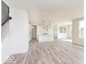 Open-concept living space featuring wood floors, recessed lighting, and seamless flow to the modern kitchen at 6818 Jacone Dr, Brownsburg, IN 46112