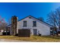 Exterior of home with stone chimney and siding, fenced in yard at 7837 Hunters Path, Indianapolis, IN 46214
