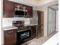 Modern kitchen with stainless steel appliances and dark wood cabinets at 7837 Hunters Path, Indianapolis, IN 46214
