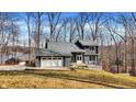 Charming two-story home with stone accents, a two-car garage, and a deck overlooking a tree-filled yard at 7899 S Timber Cliff Ln, Trafalgar, IN 46181