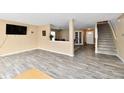 Open floor plan living room with wood floors, staircase, and views into the dining room at 8630 Aylesworth Dr, Camby, IN 46113