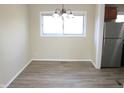Well-lit dining area featuring sleek floors and a modern light fixture, conveniently situated near stainless steel fridge at 9238 Celtic Ct, Indianapolis, IN 46235