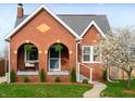 Charming brick home with arched porch and manicured lawn with flowering tree at 1014 Shannon Ave, Indianapolis, IN 46201